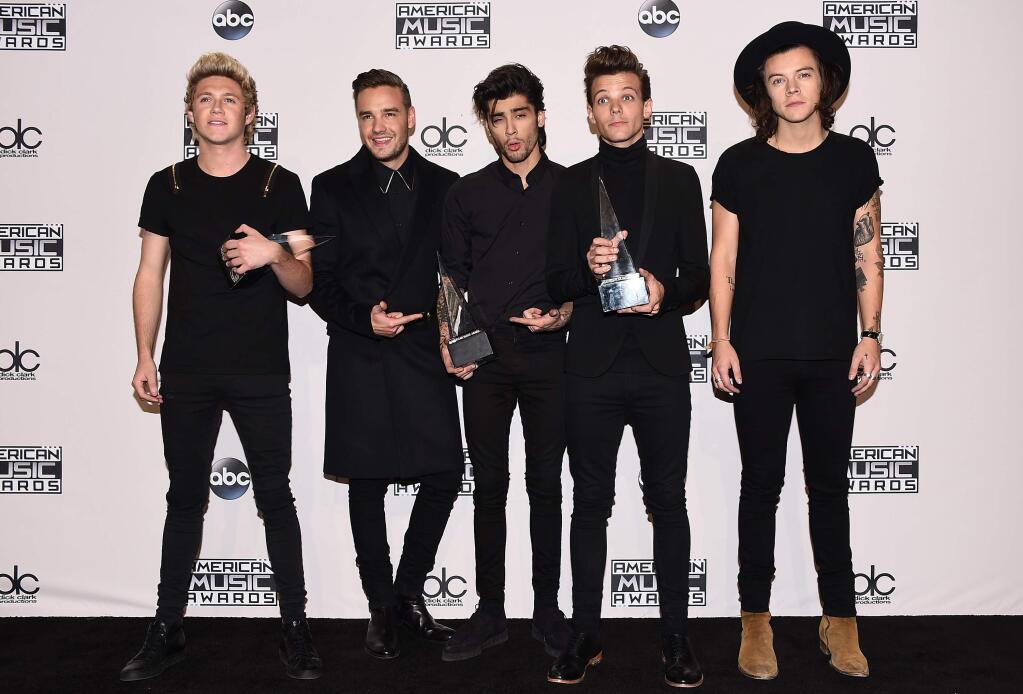 Niall Horan, from left, Liam Payne, Zayn Malik, Louis Tomlinson and Harry Styles, of One Direction, pose in the press room with the awards for artist of the year, favorite pop/rock album for Midnight Memories and pop/rock band, duo or group at the 42nd annual American Music Awards at Nokia Theatre L.A. Live on Sunday, Nov. 23, 2014, in Los Angeles. (Photo by Jordan Strauss/Invision/AP)