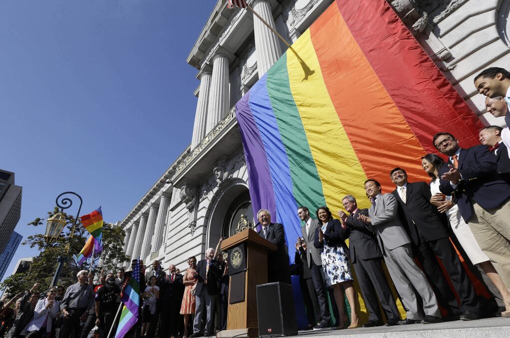 San Francisco Mayor Ed Lee, center, speaks at a news conference outside of City Hall in San Francisco, Friday, June 26, 2015, after the U.S. Supreme Court ruled that same-sex couples have the right to marry nationwide. The court's 5-4 ruling means the remaining 14 states, in the South and Midwest, will have to stop enforcing their bans on same-sex marriage. (AP Photo/Jeff Chiu)