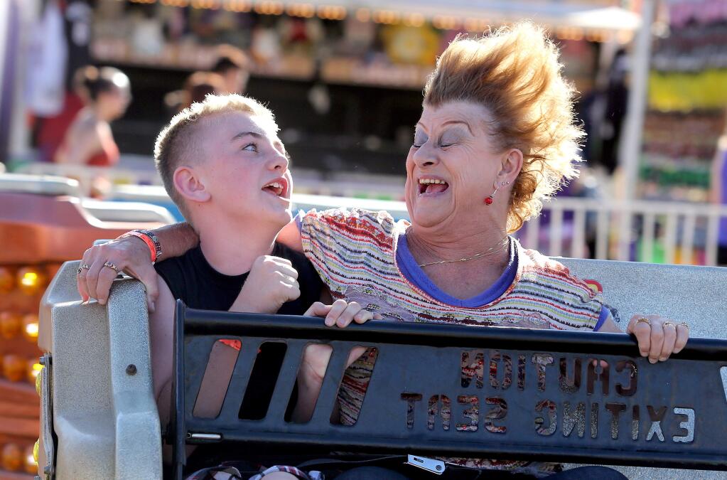 Joseph Wilson, 10, left, and his grandma Anne Bradley, right, of Santa Rosa road the 'Sizzler,' during opening day at the Sonoma County Fair, Thursday, July 24, 2014. (Crista Jeremiason / The Press Democrat)