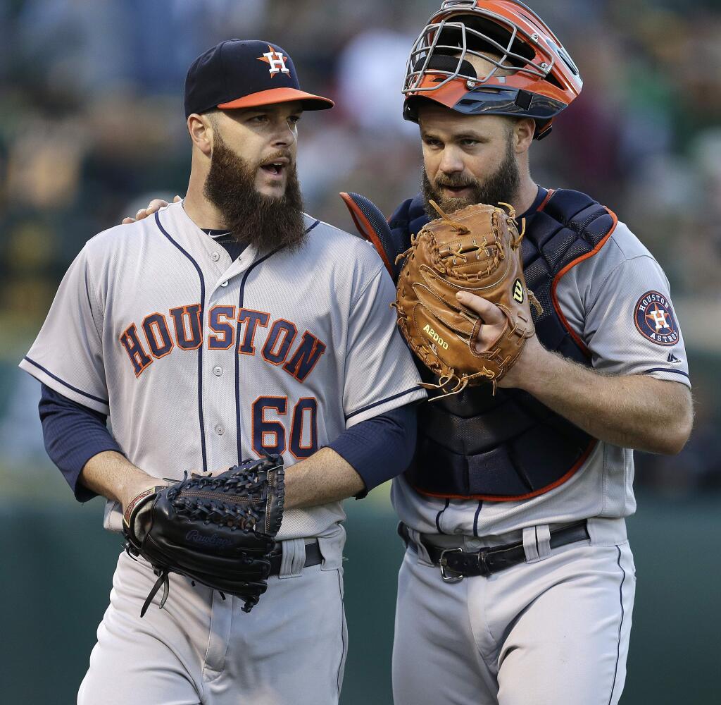 Houston Astros' Dallas Keuchel, left, and Evan Gattis speak in the second inning of a baseball game against the Oakland Athletics Tuesday, July 19, 2016, in Oakland, Calif. (AP Photo/Ben Margot)
