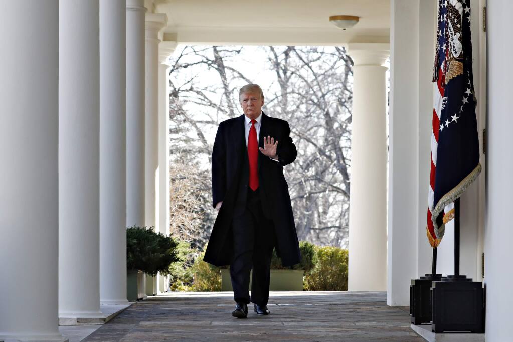 President Donald Trump waves as he walks through the Colonnade from the Oval Office of the White House on arrival to announce a deal to temporarily reopen the government, Friday, Jan. 25, 2019, from the Rose Garden of the White House in Washington. (AP Photo/Jacquelyn Martin)