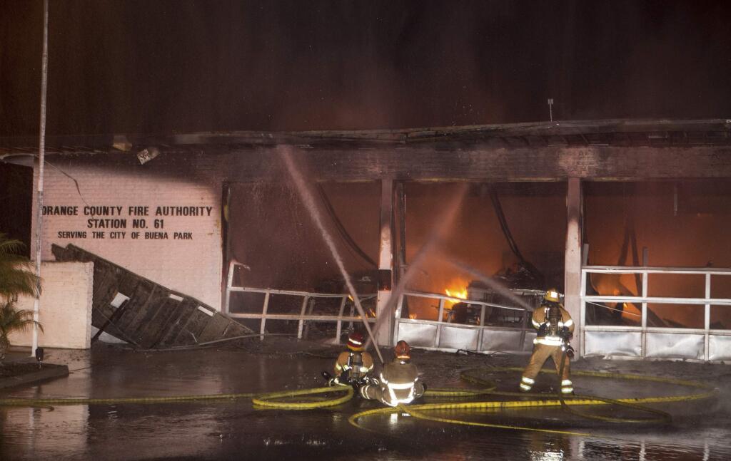 Firefighters battle a two alarm fire ripped through Orange County Fire Authority Station 6 in Buena Park, Calif. on Thursday, Jan. 12, 2017. County Fire Authority Captain Larry Kurtz says more than 50 firefighters worked in pounding rain to extinguish the flames, which heavily damaged the station and destroyed at least one truck inside. Officials say nobody was hurt in the fire that broke out around 4:30 a.m. Thursday at the fire station in Buena Park near the Knott's Berry Farm amusement park. (AP Photo/Kevin Warn)