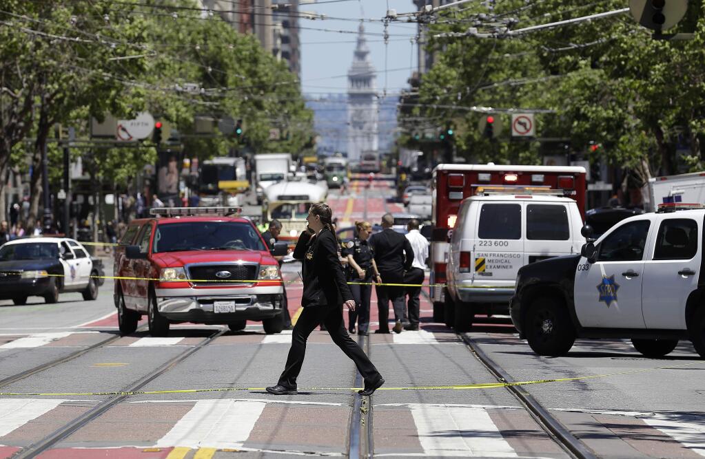 Police officers and officials patrol along Market Street after a shooting in San Francisco, Wednesday, May 3, 2017. (AP Photo/Jeff Chiu)