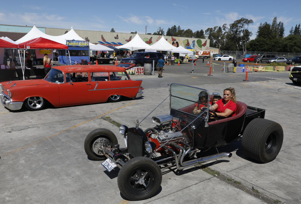 Angel Peter drives Daniel Trevino, 7, and her daughter Naitalya Peter, 7, in her vintage Ford hot rod during the Rollin' Rosies Poker Run and Raffle event at the Mitote Food Park on Sebastopol Road, in Santa Rosa on Sunday, May 15, 2022.(Beth Schlanker/The Press Democrat)