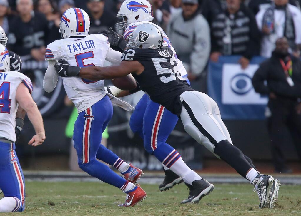 Oakland Raiders defensive end Khalil Mack sacks Buffalo Bills quarterback Tyrod Taylor, and later recovers the fumble, late in the fourth quarter during their game in Oakland on Sunday, December 4, 2016. The Raiders defeated the Panthers 38-24.(Christopher Chung/ The Press Democrat)