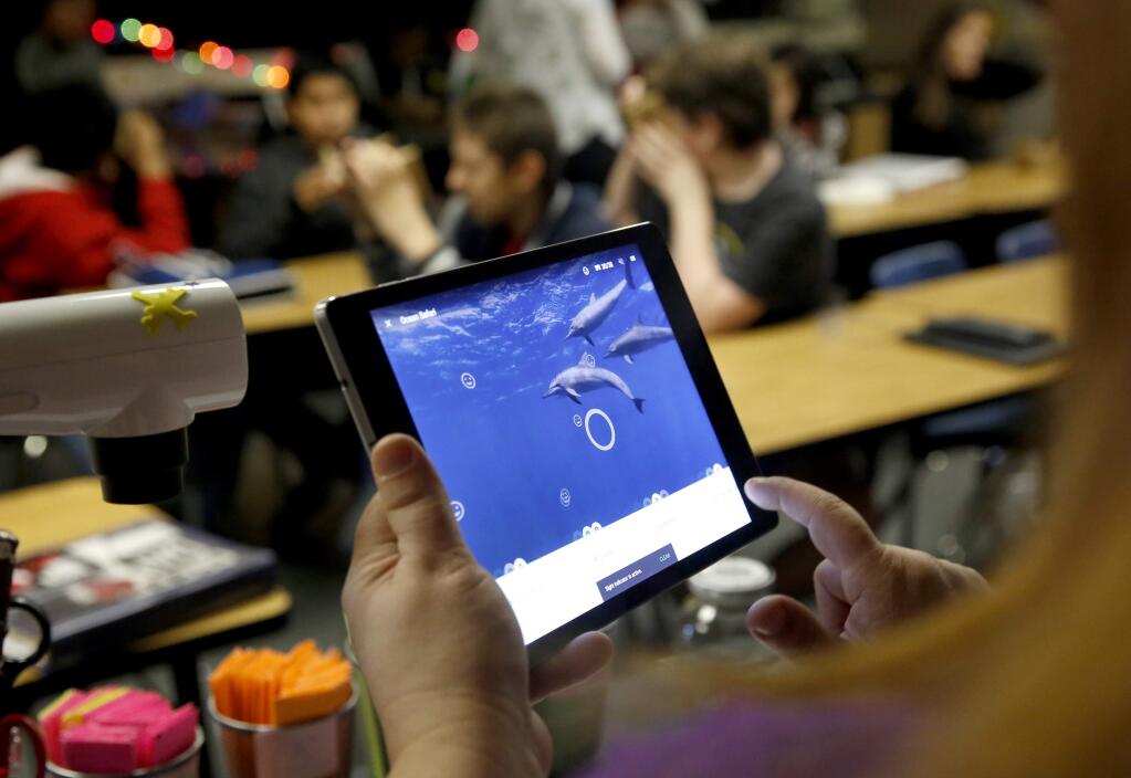 A teacher directs students as they use smartphones and a Google Cardboard viewing device to explore the ocean in a virtual reality as part of Google's Expeditions Pioneer Program that visited Hilliard Comstock Middle School in Santa Rosa, on Thursday, November 5, 2015. (BETH SCHLANKER/ The Press Democrat)