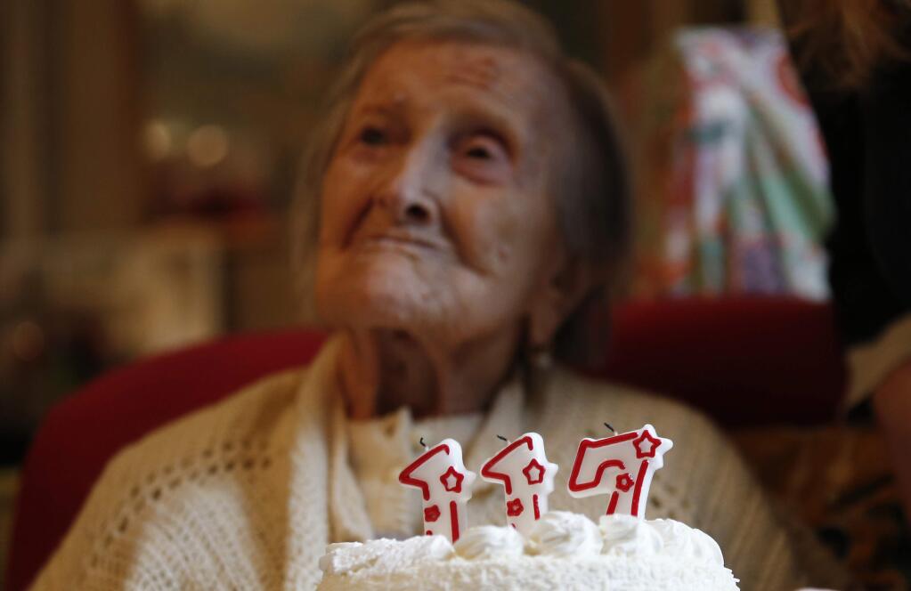 Emma Morano is pictured behind a cake with candles marking her 117th birthday in Verbania, Italy, Tuesday, Nov. 29, 2016. (AP Photo/Antonio Calanni)