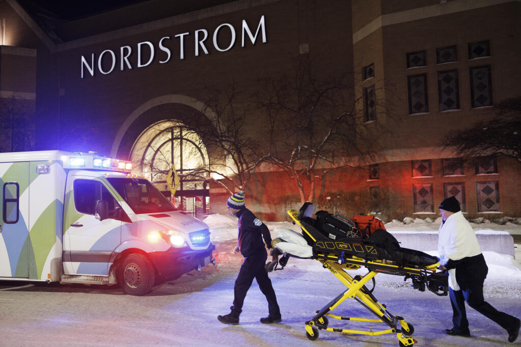 Two first responders and an ambulance are seen at the entrance to Nordstrom at the Mall of America in Bloomington, Minn., after reports of shots fired on Friday, Dec. 23, 2022. (Kerem Yücel/Minnesota Public Radio via AP)