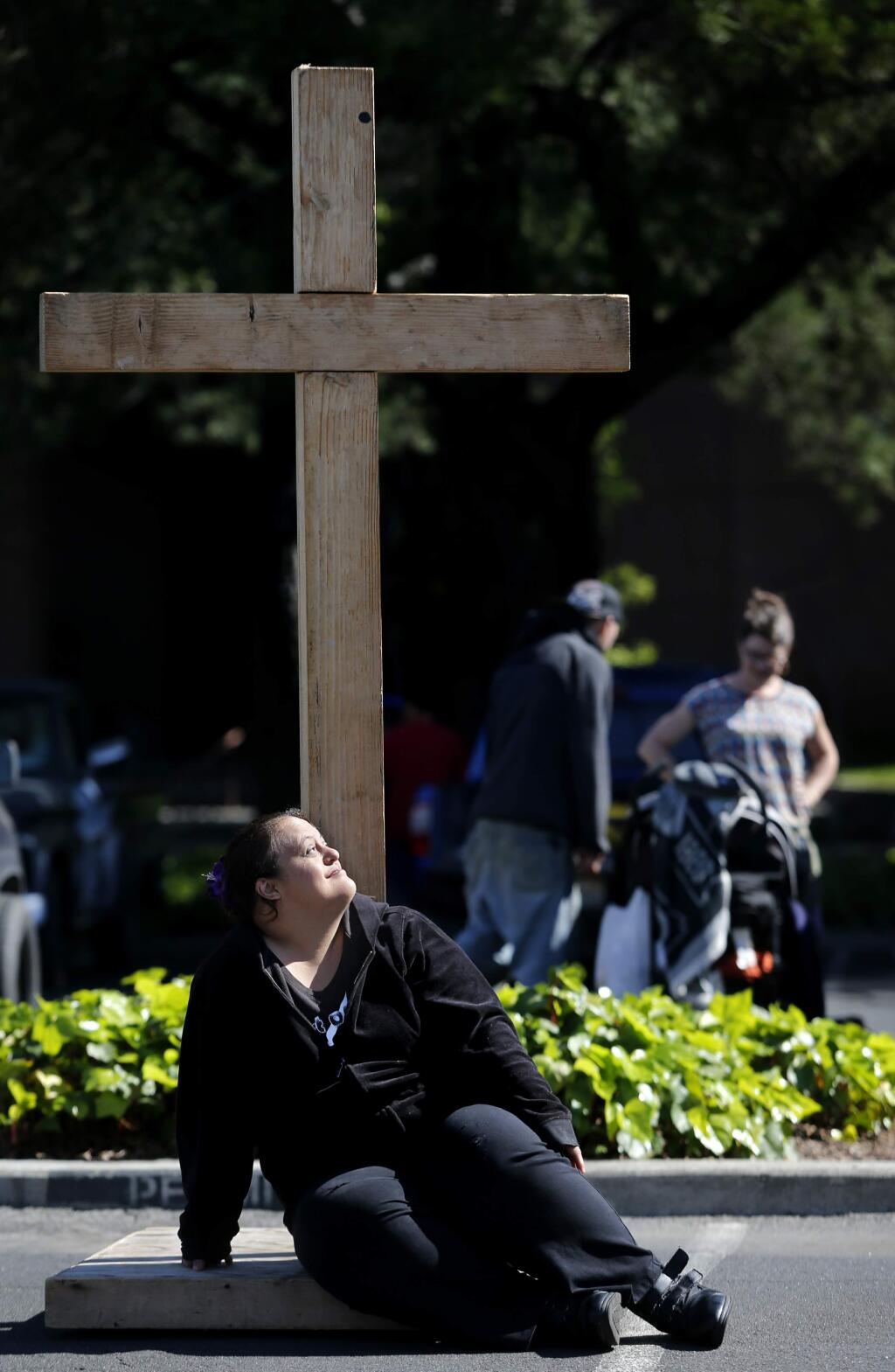 Angel Huerta rests during an Easter worship service organized by SOMA Church Community in the parking lot of City Hall in Santa Rosa, on Sunday, March 27, 2016. (BETH SCHLANKER/ The Press Democrat)