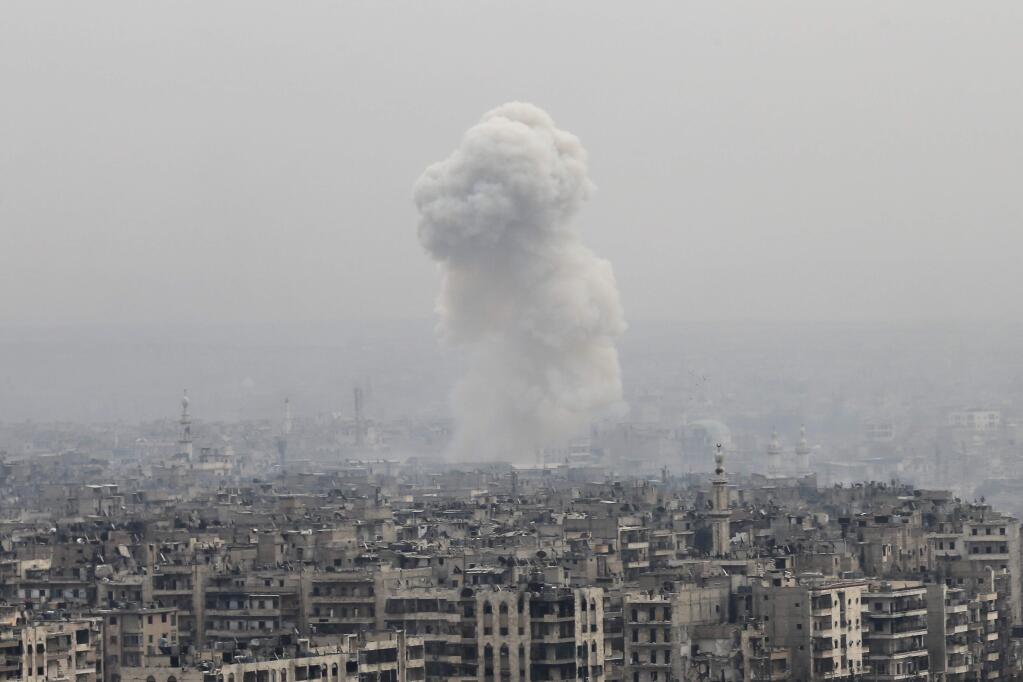 FILE -- In this Monday, Dec. 5, 2016 file photo, smoke rises following an air strike hits insurgents positions in eastern neighborhoods of Aleppo, Syria. (AP Photo/Hassan Ammar, File)