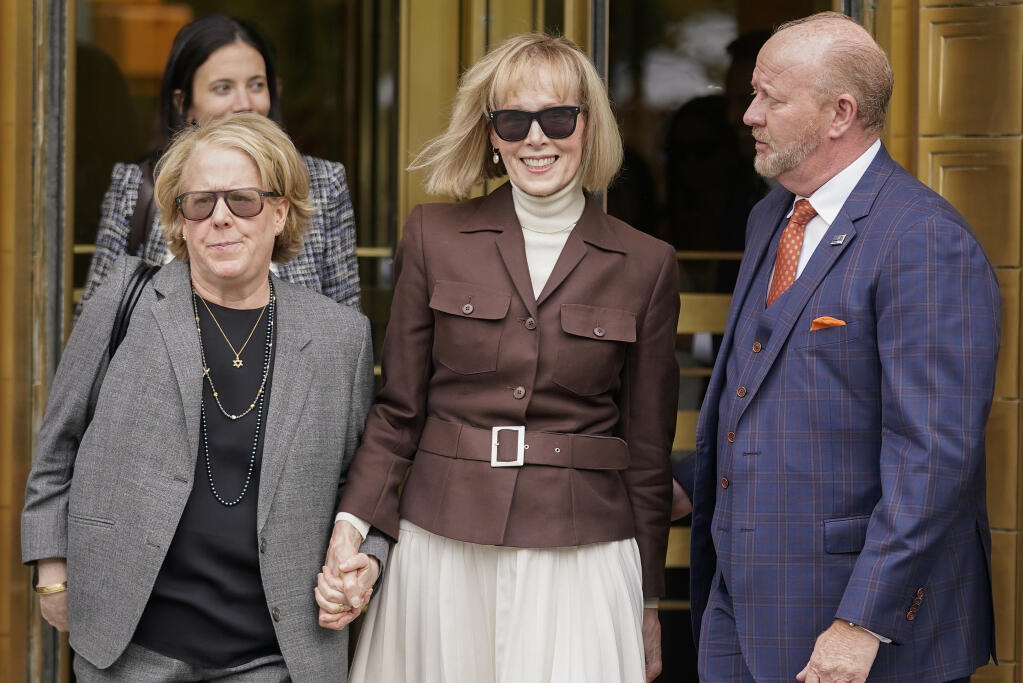E. Jean Carroll, center, walks out of Manhattan federal court, Tuesday, May 9, 2023, in New York. A jury has found Donald Trump liable for sexually abusing the advice columnist in 1996, awarding her $5 million in a judgment that could haunt the former president as he campaigns to regain the White House. (AP Photo/John Minchillo)