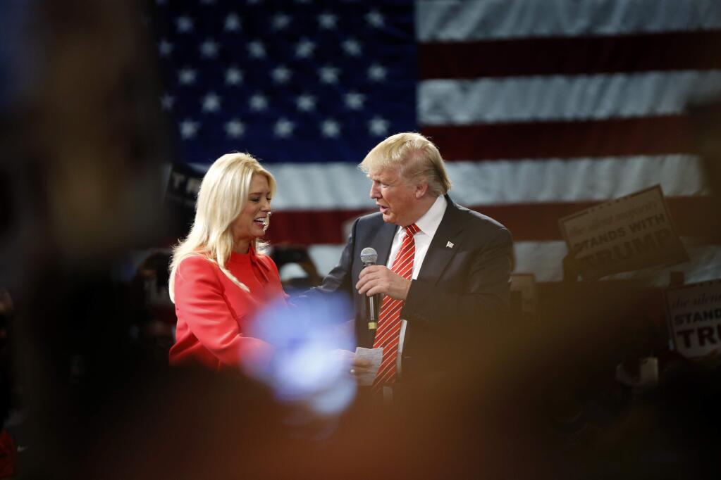 Donald Trump is greeted by Florida Attorney General Pam Bondi at a March 14 campaign event in Tampa. (GERALD HERBERT / Associated Press)