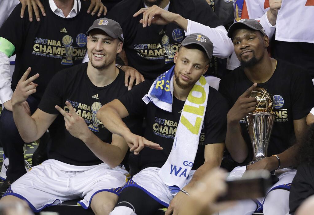 Golden State Warriors guard Klay Thompson, from left, guard Stephen Curry and forward Kevin Durant celebrate after Game 5 of basketball's NBA Finals against the Cleveland Cavaliers in Oakland, Calif., Monday, June 12, 2017. The Warriors won 129-120 to win the NBA championship. (AP Photo/Marcio Jose Sanchez)