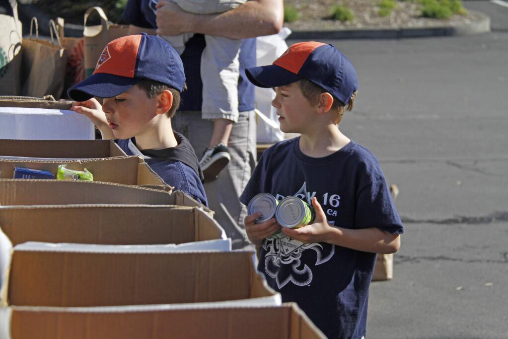 Bill Hoban/Index-TribuneSorting food for FISHCub Scouts Sean Brady, 6, left, and Miles Tracy, 6, both with the Tiger Den in Pack 16, sort food Saturday during the annual Scout Food Drive for FISH's holiday baskets. The Scouts collected about 2,700 pounds of food. That was about half the amount they collected in previous years.