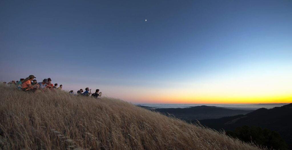 Hikers wait for sunset and the beginning of the many Fourth of July fireworks displays visable from near the summit of Bald Mountain, in Sugarloaf Ridge State Park. (Diane Askew)