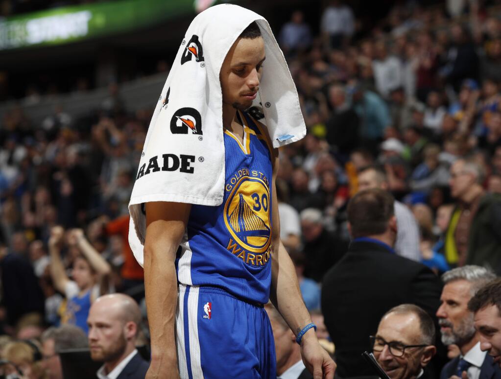 Golden State Warriors guard Stephen Curry heads to the bench with a towel over his head as the Warriors fell behind the Denver Nuggets in the second half of an NBA basketball game Monday, Feb. 13, 201, in Denver. The Nuggets won 132-110. (AP Photo/David Zalubowski)