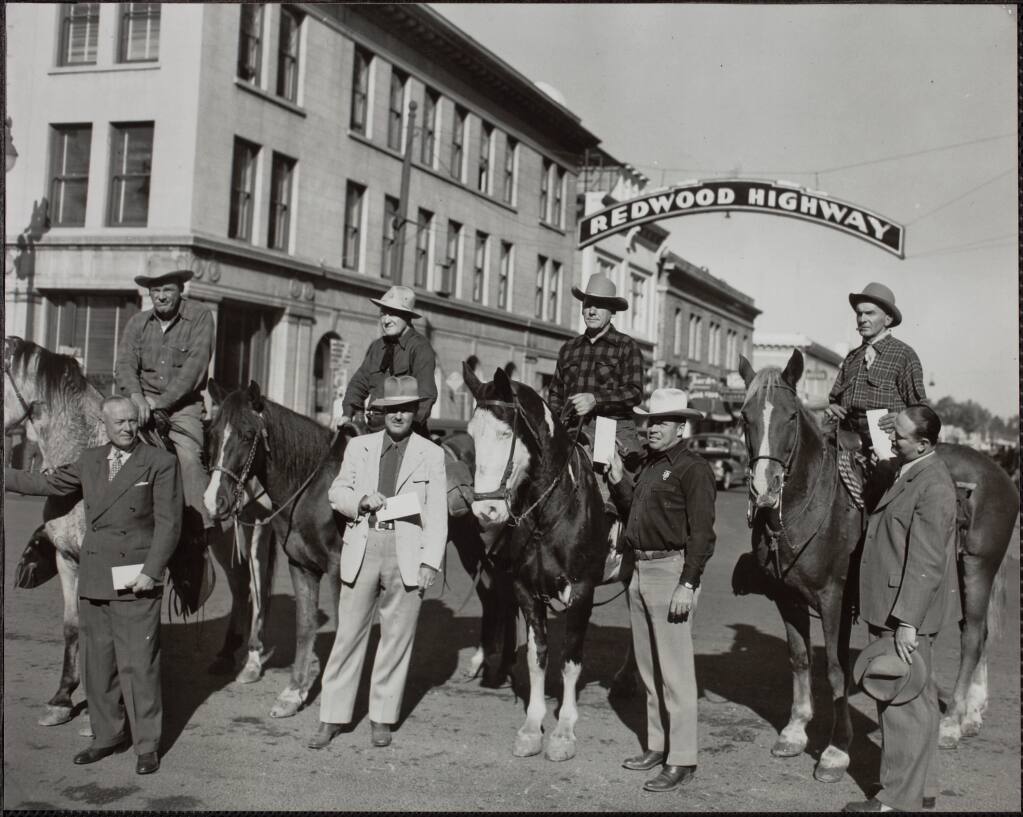 The Redwood Rangers pose in front of the Redwood Highway banner downtown Santa Rosa on Oct. 12, 1947 before leaving for the California State Horsemen Association Convention in Stockton. On horseback, from left, Leo O'Connors, John F. "Jack" Luttrell, David Grant and Jack Williams. The standing men, from left, are Joseph Obert Pedersen, mayor of Santa Rosa; Clifton Elzo McCluskey, president of the Sonoma County Driving and Riding Club and regional vice president of the California State Horsemen's Association; Warren Richardson, president of the Sonoma County Trailblazers and founder of the California Centaurs; and Herbert J. Waters, editor of The Press Democrat. (The Press Democrat/Sonoma County Library)