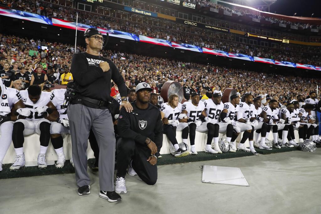 Some members of the Oakland Raiders kneel during the national anthem before their game Sunday against the Washington Redskins. (ALEX BRANDON / Associated Press)