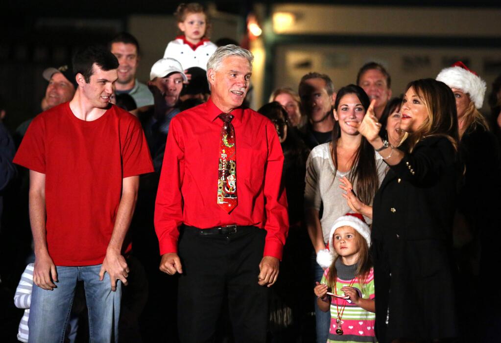 Sabrina Soto, right, a judge on the television show 'The Great Christmas Light Fight!' on ABC talks to Scott Weaver, center, and his son Tyler, left, during filming of the reveal of his Christmas decorations at his Rohnert Park home, Wednesday, October 15, 2014. (Crista Jeremiason / The Press Democrat)