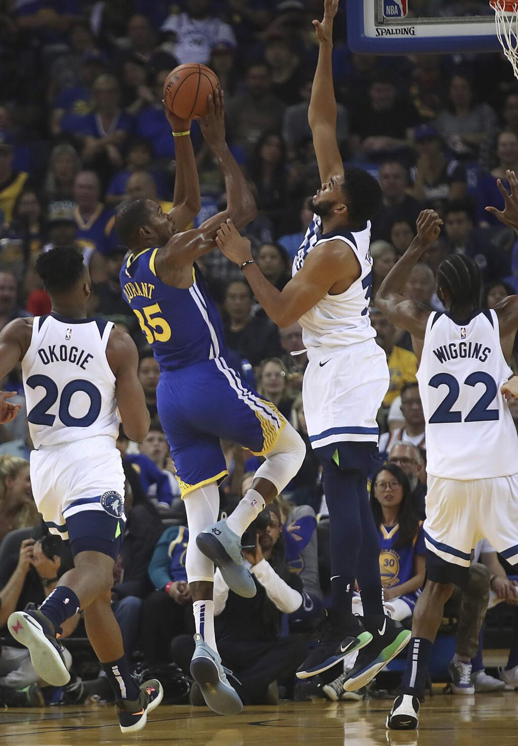 Golden State Warriors' Kevin Durant (35) shoots as Minnesota Timberwolves' Karl-Anthony Towns (32) defends during the first half of an NBA basketball game Friday, Nov. 2, 2018, in Oakland, Calif. (AP Photo/Ben Margot)
