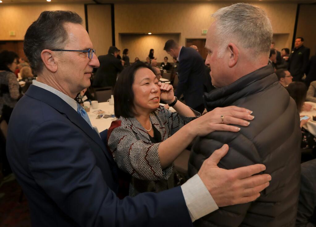 Sonoma State University President Judy Sakaki wipes away a tear as she and her husband, Patrick McCallum, left, reunite with Santa Rosa firefighter Tony Niel who along with another firefighter, rescued the two in Fountaingrove during the early hours of the Tubbs fire in October. Sakaki honored the firefighters during the Project: Rebuild, sponsored by the North Bay Business Journal at the DoubleTree Hotel in Rohnert Park on Friday March 2, 2018. (KENT PORTER/ PD)