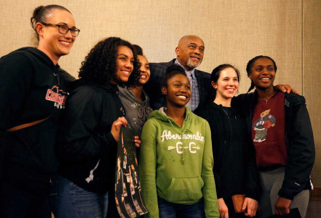 Record-breaking Olympic track and field medalist Dr. Tommie Smith, center, poses for a photograph with members of the Cardinal Newman girls basketball team and head coach Monica Mertle, left, at Sonoma State University in Rohnert Park on Tuesday, April 11, 2017. (Alvin Jornada / The Press Democrat)