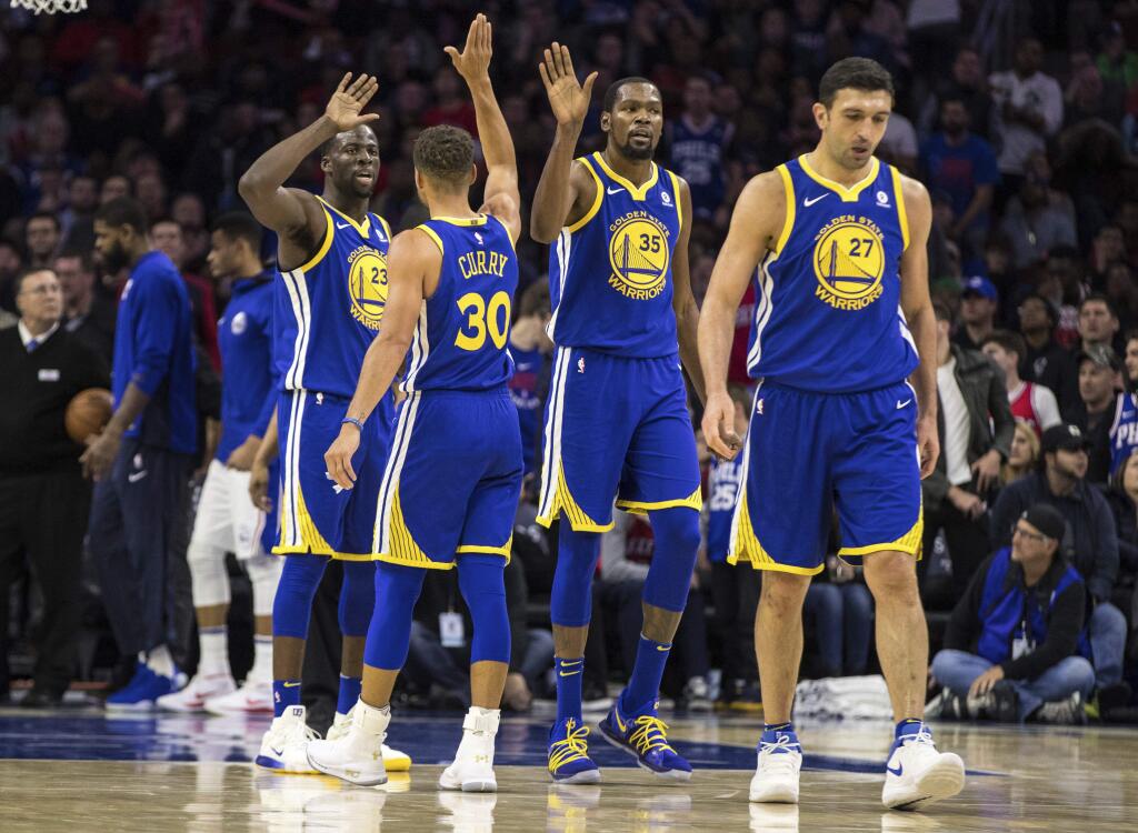 The Golden State Warriors' Stephen Curry (30) high-fives to Kevin Durant, center right, and Draymond Green, left, during the second half against the Philadelphia 76ers, Saturday, Nov. 18, 2017, in Philadelphia. The Warriors won 124-116. (AP Photo/Chris Szagola)