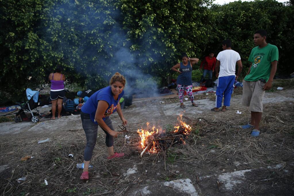 Migrants light a fire for cooking as a thousands-strong caravan of Central Americans hoping to reach the U.S. border stops for the night, in Matias Romero, Oaxaca state, Mexico, Thursday, Nov. 1, 2018. Most of the main caravan of Central American migrants spent a rain-drenched night outside, before continuing their slow walk through southern Mexico.(AP Photo/Rebecca Blackwell)