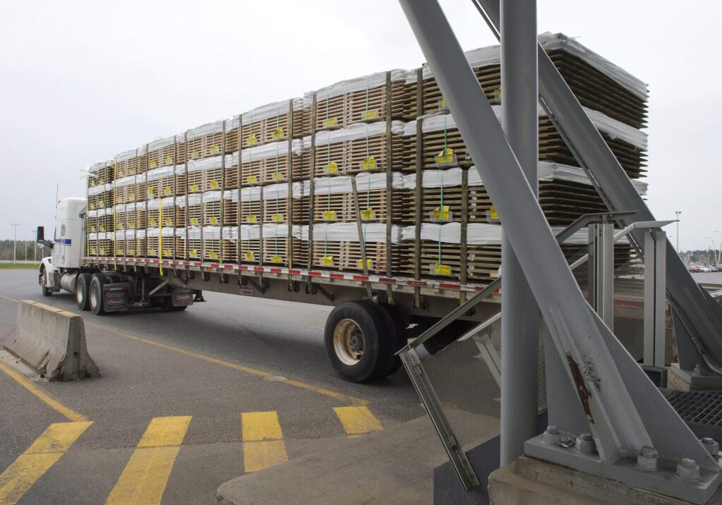 A truck carrying wood goes through the customs checkpoint, Tuesday, April 25, 2017 in Champlain, N.Y. (Ryan Remiorz/The Canadian Press via AP)