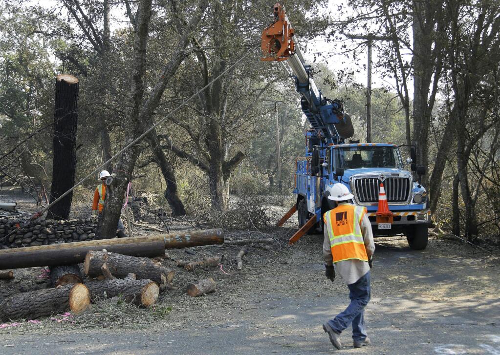 FILE - In this Oct. 18, 2017 file photo, a Pacific Gas & Electric crew work on replacing poles in Glen Ellen, Calif. A report says California utilities have delayed efforts for nearly a decade to map where power lines pose the greatest wildfire risk. The report Sunday, Oct. 22, in The Mercury News comes as the state investigates whether downed power lines owned by Pacific Gas & Electric Co. sparked the deadliest wildfires in California history. (AP Photo/Ben Margot, File)