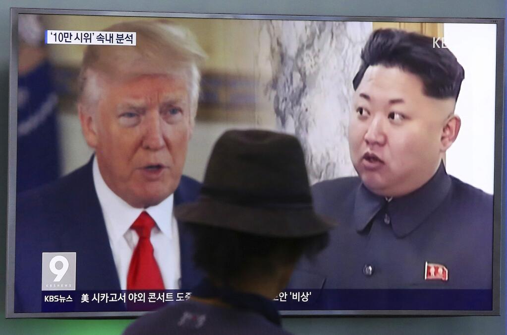 FILE - In this Aug. 10, 2017, file photo, a man watches a TV screen showing U.S. President Donald Trump and North Korean leader Kim Jong Un, right, during a news program at the Seoul Train Station in Seoul, South Korea. (AP Photo/Ahn Young-joon, File)