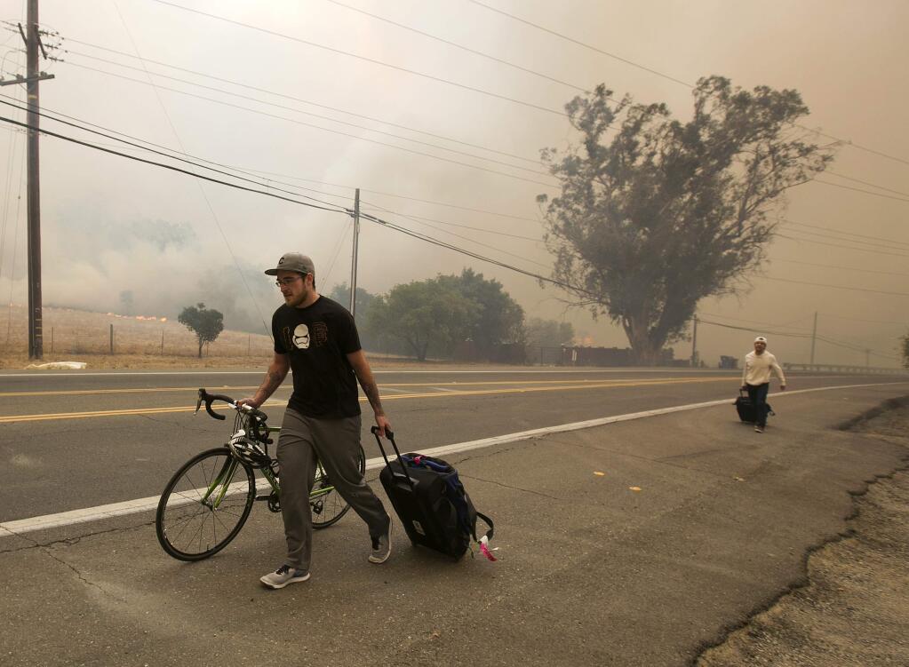 Area residents evacuate as flames from a massive wildfire approach their homes Monday, Oct. 9, 2017, in Napa, Calif. (AP Photo/Rich Pedroncelli)