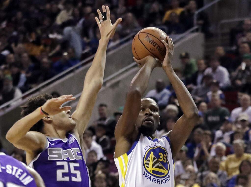 Golden State Warriors forward Kevin Durant, right, shoots as Sacramento Kings forward Justin Jackson defends during the first half of a preseason game Friday, Oct. 5, 2018, in Seattle. (AP Photo/Ted S. Warren)