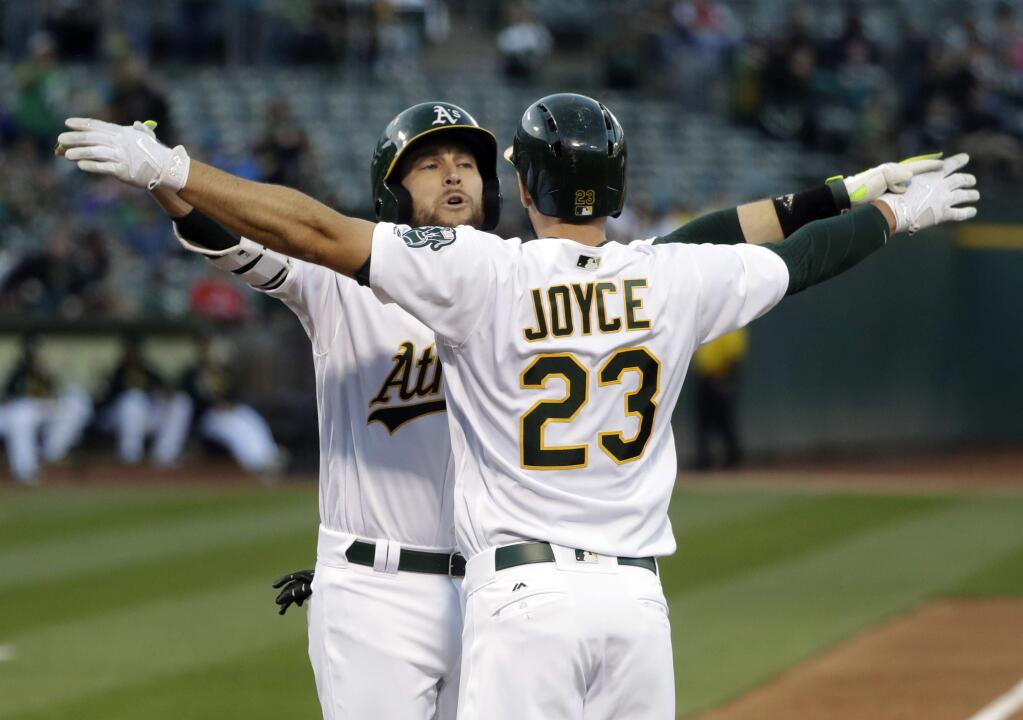 The Oakland Athletics' Jed Lowrie, left, celebrates his two-run home run at the plate with teammate Matt Joyce during the first inning Thursday, May 18, 2017, in Oakland. (AP Photo/Marcio Jose Sanchez)