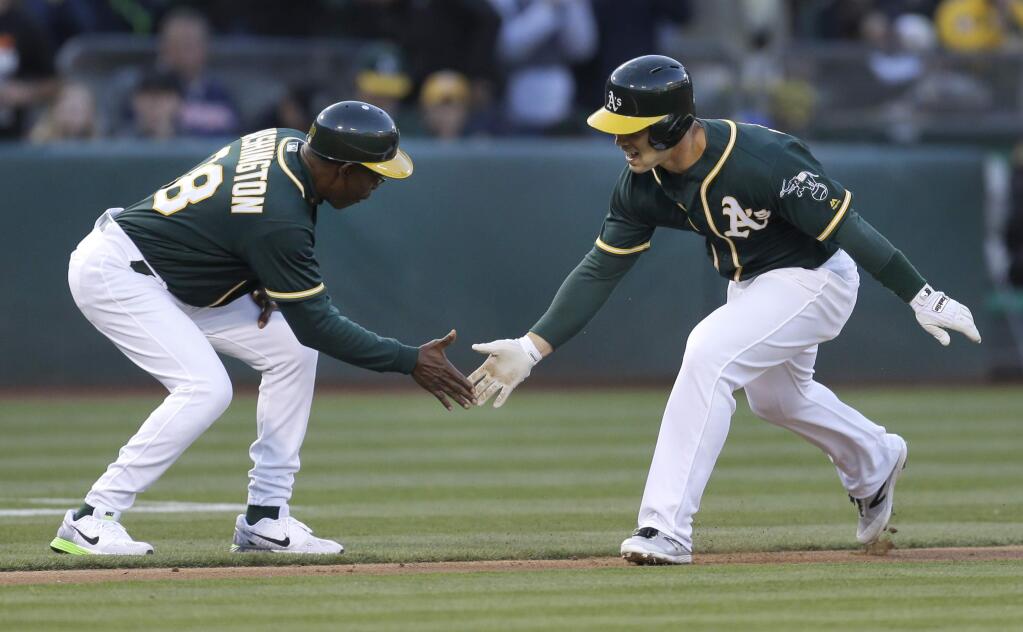 Oakland Athletics' Jake Smolinski, right, celebrates with third base coach Ron Washington after hitting a two run home run off Texas Rangers' Derek Holland in the third inning of a baseball game Wednesday, June 15, 2016, in Oakland, Calif. (AP Photo/Ben Margot)