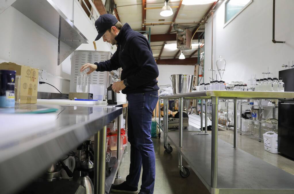 Josh Opatz, co-founder of Young & Yonder Spirits, uses alcohol made at his Healdsburg distillery to make hand sanitizer, on Tuesday, March 24, 2020. Opatz is giving the hand sanitizer away for free to the local community. (Christopher Chung/ The Press Democrat)