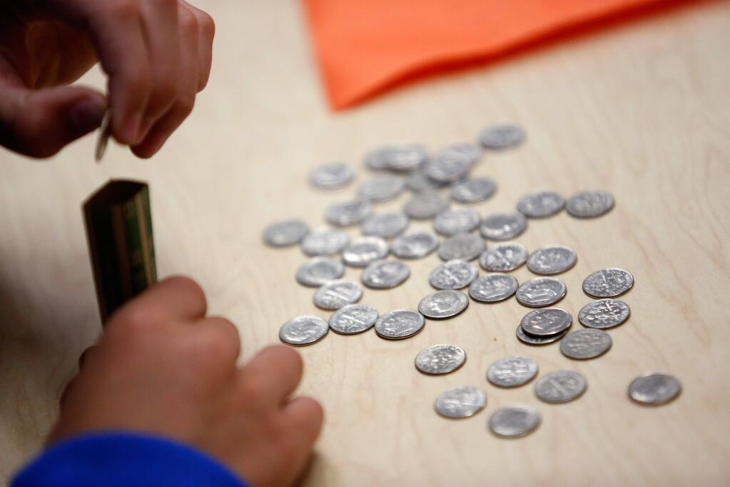 Slater Middle School eighth grader Noah Warnell, 13, counts money he collected with his leadership class peers in a fundraiser for the Star of Hope Centre for Children located in Kenya on Friday, May 13, 2016. (Alvin Jornada / The Press Democrat)