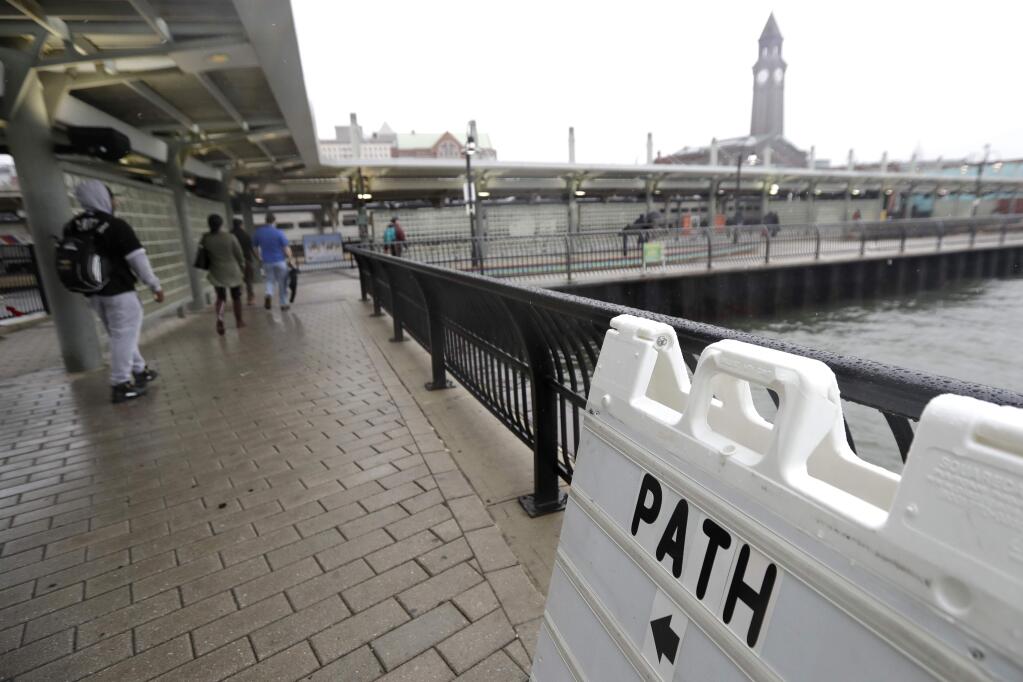 Commuters walk near the light rail station at the Hoboken Terminal, Friday, Sept. 30, 2016, in Hoboken, N.J. Commuters are using alternative travel in and out of Hoboken a day after a commuter train crashed into the rail station, killing one person and injuring more than 100 people. (AP Photo/Julio Cortez)