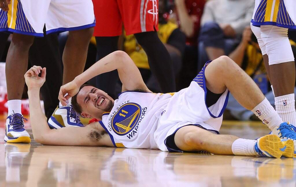 Klay Thompson writhes in pain after being kneed in the side of his head Wednesday in Game 5 of the Western Conference final series. (Christopher Chung / The Press Democrat)
