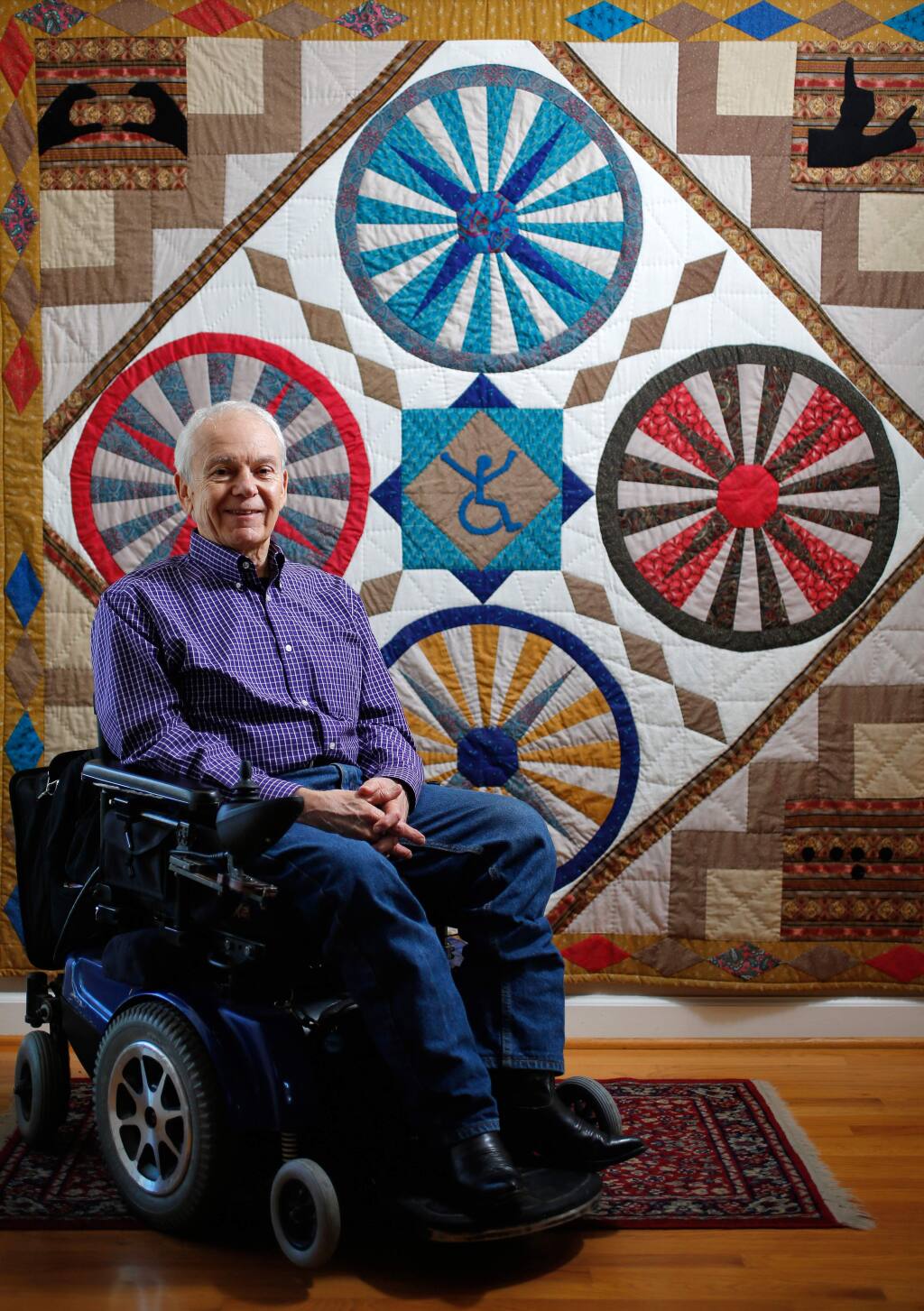 Disability advocate Anthony Tusler in front of a disability-themed quilt at his home in Penngrove on Friday, Nov. 6, 2015. (Alvin Jornada / The Press Democrat)