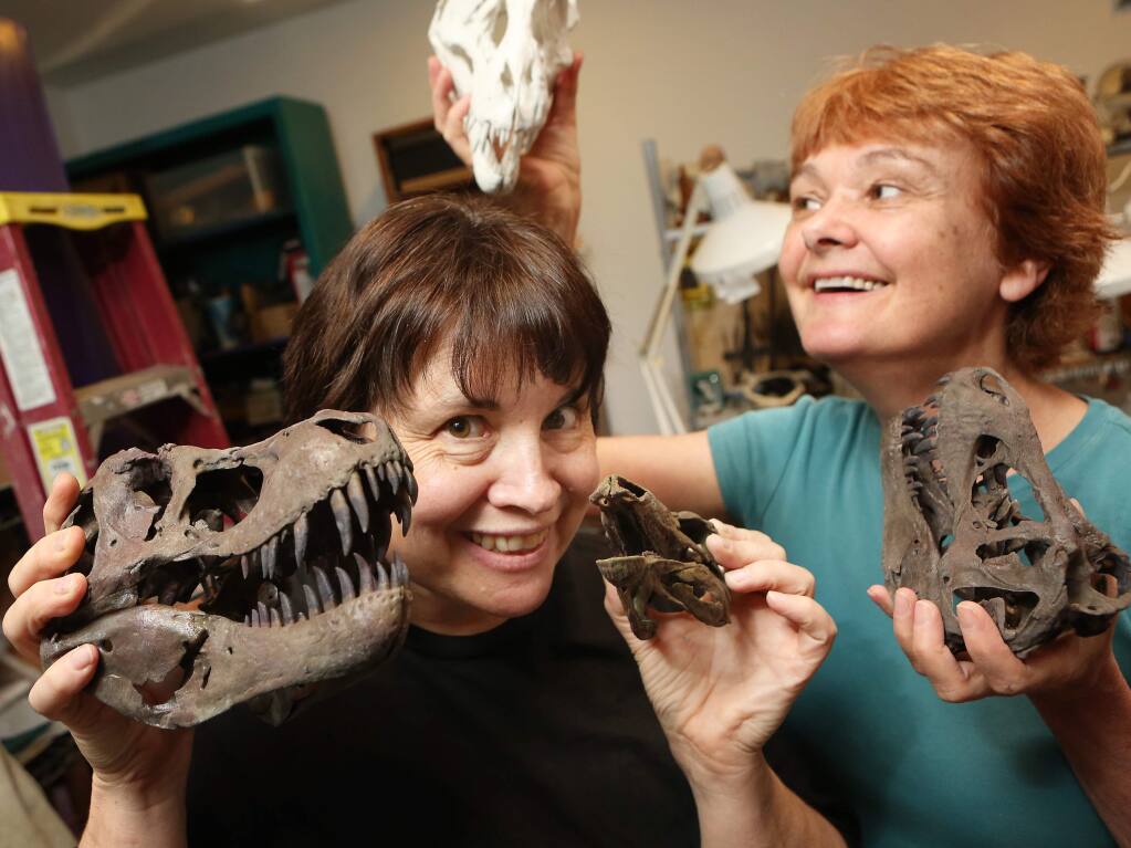 Co-owners of Images in Motion, Kamela Portuges-Robbins and Lee Armstrong hold up a scaled replicas of a Tyrannosaurus skull they built with a 3D printer at their studio in Sonoma on Tuesday, July 9, 2013. (Conner Jay/The Press Democrat)