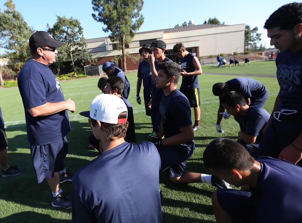 Elsie Allen High School's head football coach Bill Wight, left, talks to the players before they face off against Analy High School during Santa Rosa Junior College's Passing League, Wednesday, July 15, 2015. (Crista Jeremiason / The Press Democrat)