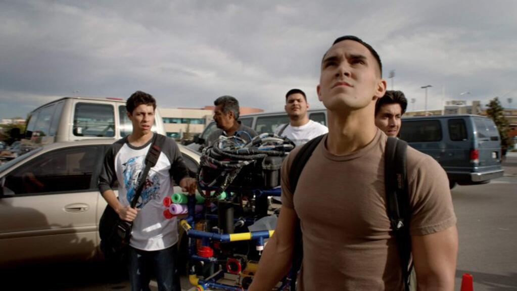George Lopez as new teacher Fredi Cameron, second from left, and Carlos Penavega, foreground, as Oscar, leads a team of undocumented Hispanic high school students form a robotics club which goes up against the country's reigning robotics champion, MIT. (Lionsgate)