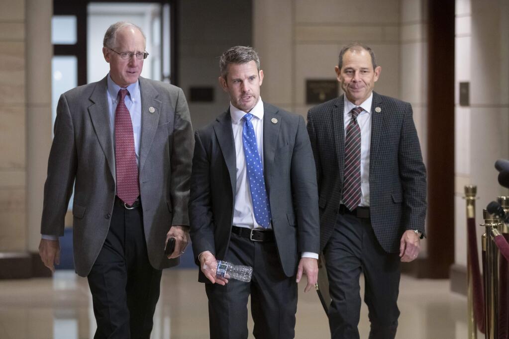 House Agriculture Committee Chairman Mike Conaway, R-Texas, Rep. Adam Kinzinger, R-Ill., and Rep. John Curtis, R-Utah, walk to a classified security briefing on the murder of Jamal Khashoggi and Saudi Arabia's war in Yemen, on Capitol Hill in Washington, Thursday, Dec. 13, 2018. (AP Photo/J. Scott Applewhite)