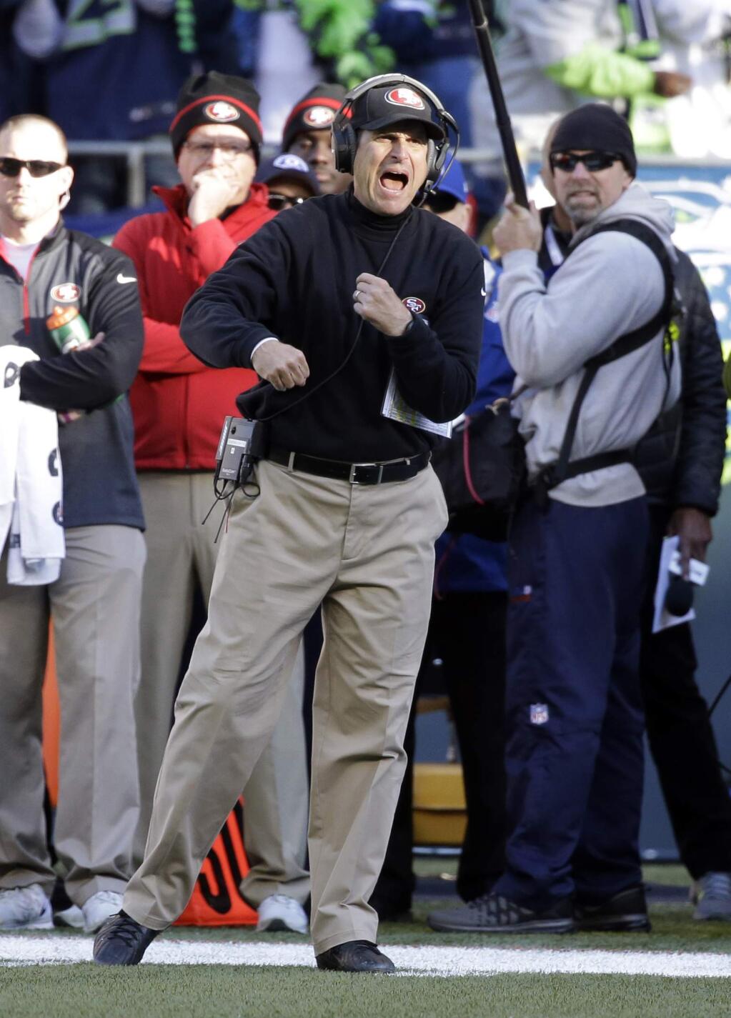 San Francisco 49ers head coach Jim Harbaugh yells from the sideline in the first half of an NFL football game against the Seattle Seahawks, Sunday, Dec. 14, 2014, in Seattle. (AP Photo/Elaine Thompson)