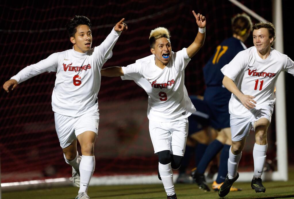 Montgomery's Bryan Rosales (6), left, Alan Soto (9), and Zack Batchelder (11) celebrate after Rosales scored the Vikings first goal of the game during the first half of the NCS boys soccer semifinal match between Ygnacio Valley and Montgomery high schools in Santa Rosa, California, on Wednesday, February 21, 2018. (Alvin Jornada / The Press Democrat)