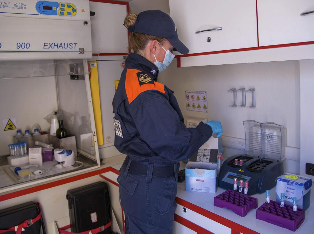 In this picture taken on Thursday, May 21, 2020, Italian Coast Guard's biologists show how they perform tests on sea water in a mobile lab during an interview with The Associated Press in Fiumicino, near Rome. Preliminary results from a survey of seawater quality during Italy's coronavirus lockdown indicate a sharp reduction in pollution from human and livestock waste in the seas off Rome. Authorities stressed it was too soon to give the lockdown sole credit for the change. (AP Photo/Domenico Stinellis)