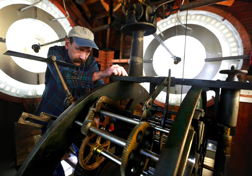 FILE - Stan Jaffe, an engineer at Keysight Technologies places the final bolt onto the mechanism that rings the bell in the 1908 E. Howard tower clock in the Empire Building in Santa Rosa's Courthouse Square. (JOHN BURGESS/ PD)