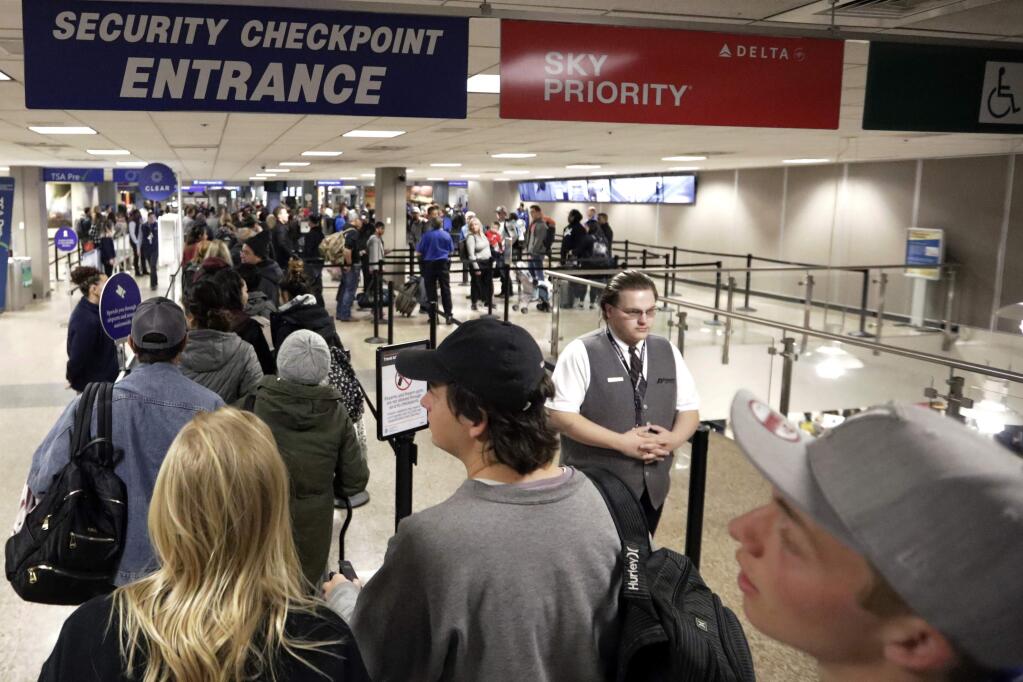 FILE - In this Wednesday, Nov. 27, 2019, file photo, travelers walk through a security checkpoint in Terminal 2 at Salt Lake City International Airport, in Salt Lake City. Federal officials are considering requiring that all travelers, including American citizens, be photographed as they enter or leave the country as part of an identification system using facial-recognition technology. (AP Photo/Rick Bowmer, File)