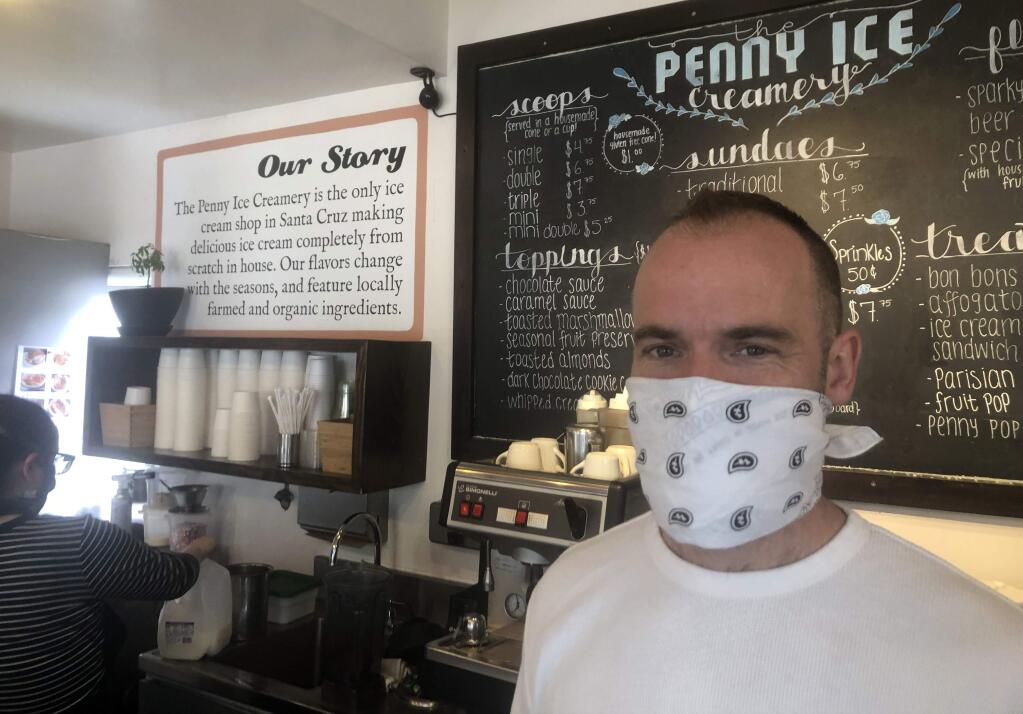 In this April 17, 2020, photo, Zachary Davis poses for a photo at The Penny Ice Creamery in Santa Cruz, Calif. An investigation by The Associated Press hows that many large companies which collectively received tens of millions of dollars in federal loans through the Paycheck Protection Program were at risk of failing even before the coronavirus walloped the economy, while others have acknowledged problems keeping their finances straight and a few have been under investigation by the Securities and Exchange Commission. That big companies and ones with questionable records received such precious financial aid during the chaotic last few weeks frustrates Davis, “We were feeling pretty good about where we were in the world. Now it's just all turned upside down,” said Davis, who had to lay off 70 workers. (AP Photo/Martha Mendoza)